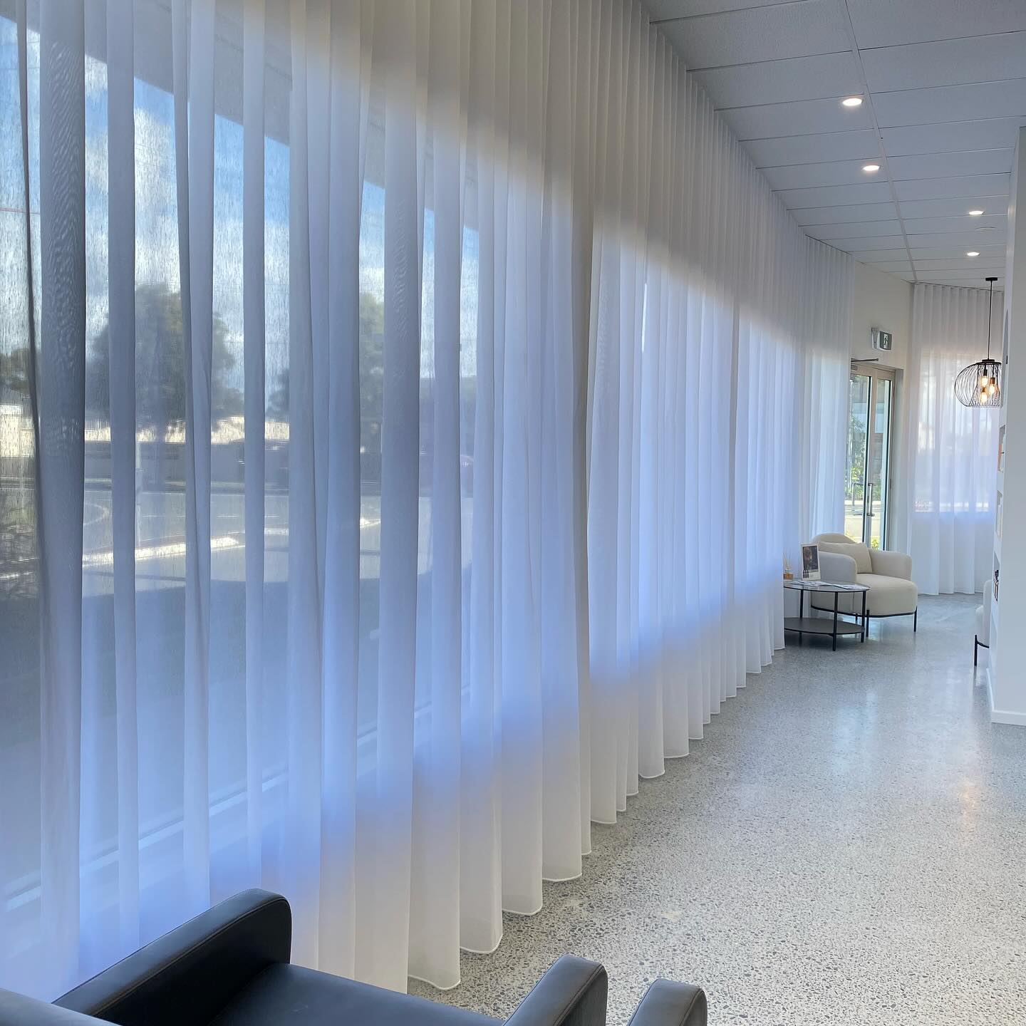 Sheer curtains along a long window wall in a bright living space